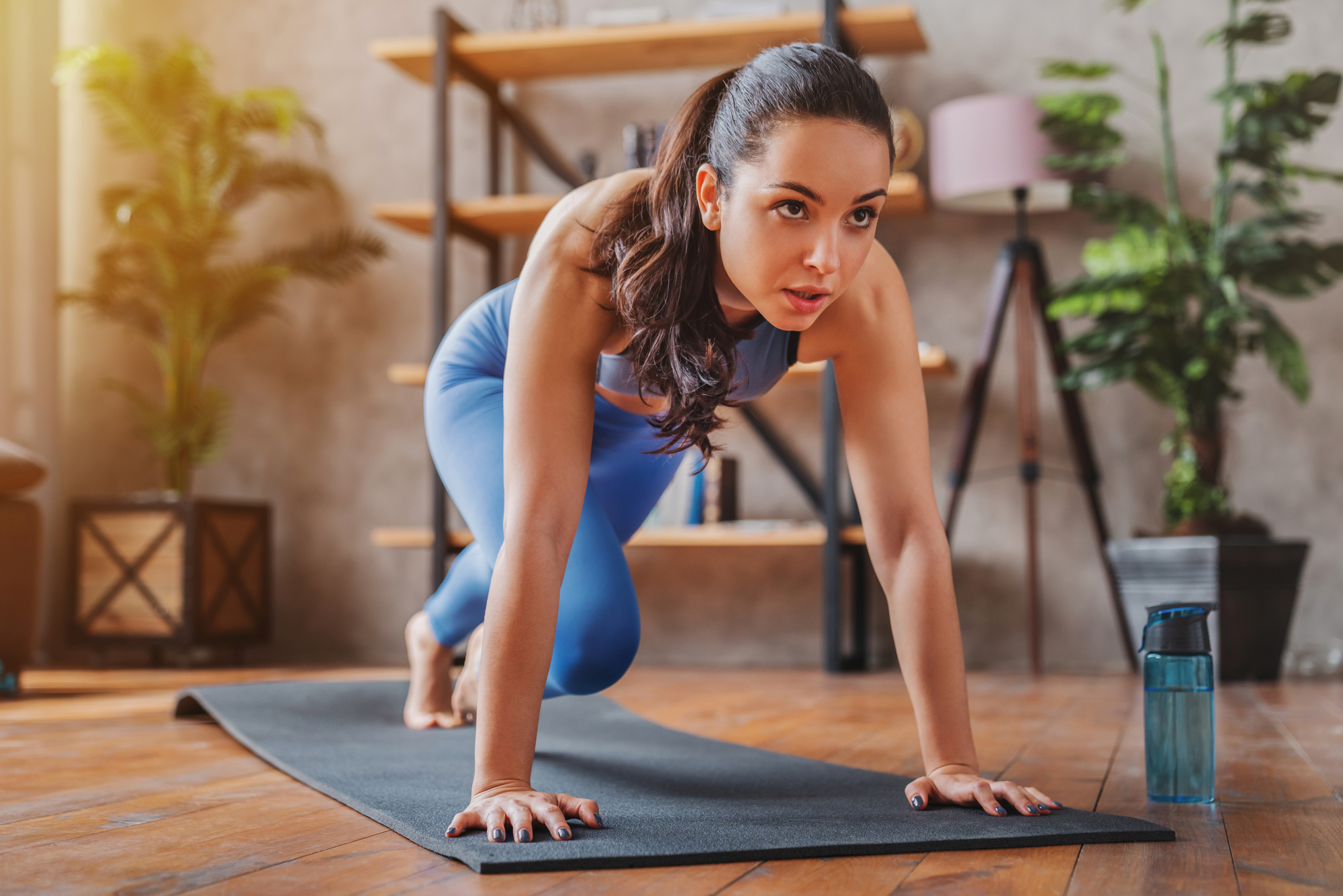 Young woman doing sport exercises indoor at home